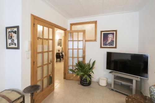 uma sala de estar com uma televisão de ecrã plano e uma televisão de ecrã plano em L'Hostalet GuestHouse em Pineda de Mar