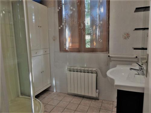 Un baño blanco con lavabo y ducha. en Gite les Pins - les gites des hauts de vialot, en Auriac-du-Périgord