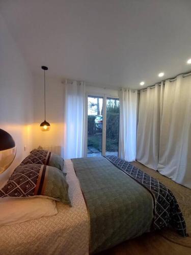 - une chambre avec un grand lit et une fenêtre dans l'établissement Superbe appartement moderne en rez-de-chaussée, à Ozoir-la-Ferrière