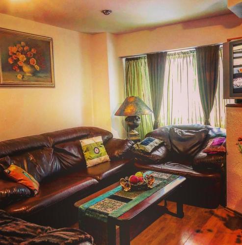 een woonkamer met een leren bank en een tafel bij Apartament ZEN in Tîrgu Ocna