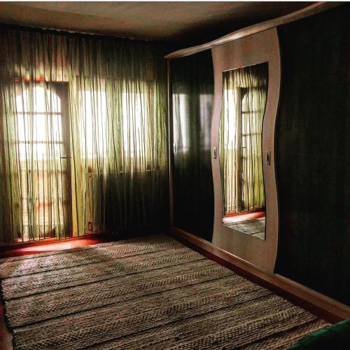 een lege kamer met twee ramen en een tapijt bij Apartament ZEN in Tîrgu Ocna