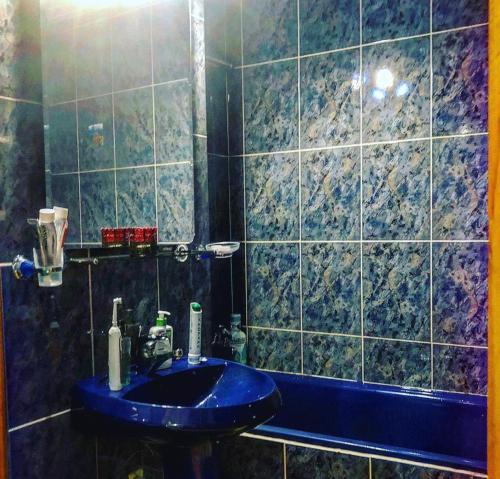 een badkamer met een blauwe wastafel en een bad bij Apartament ZEN in Tîrgu Ocna