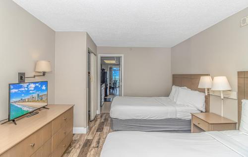 a hotel room with two beds and a flat screen tv at Landmark 1134 in Myrtle Beach