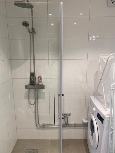 a shower in a bathroom with a washing machine at Nice guest house in Stockholm
