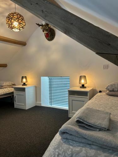 a bedroom with two beds and a window at Brannel Cottage in St Austell