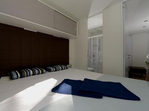 una camera da letto con un letto e un asciugamano blu di Detached chalet with AC, in a natural park on the coast a Baia Domizia
