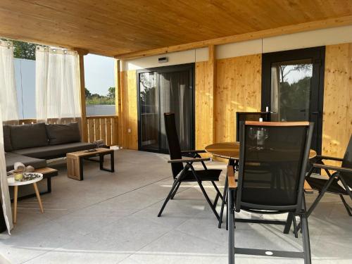 ein Wohnzimmer mit einer Couch und einem Tisch und Stühlen in der Unterkunft Vila Olson - Holiday Village Twins in Pakoštane