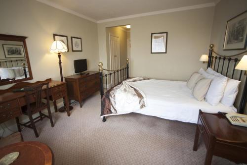 a hotel room with a large bed and a desk at The Lion Hotel Shrewsbury in Shrewsbury