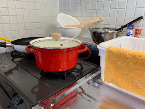 a red pot sitting on top of a stove at O2 capsule house OTARU in Otaru