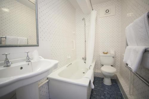 Baño blanco con lavabo y aseo en The Lion Hotel Shrewsbury en Shrewsbury