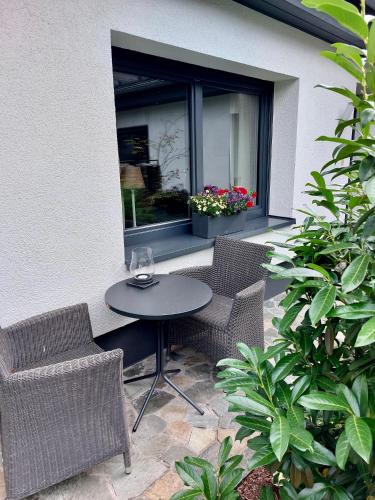 a patio with a table and chairs and a window at Gästehaus Grüne Oase in Fulda