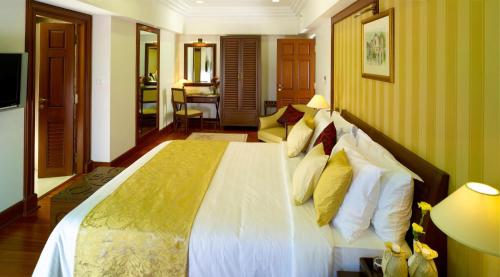 sypialnia z dużym łóżkiem z żółtymi i białymi poduszkami w obiekcie The Paul Bangalore w mieście Bengaluru
