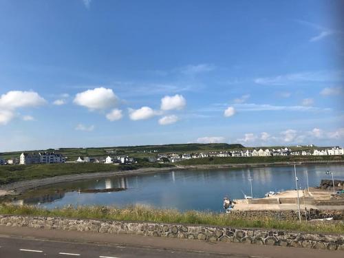 a body of water with a boat in it at Obsidian: Arguably the best view in Portballintrae in Portballintrae