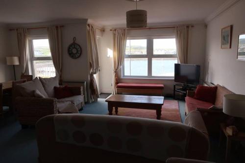 a living room with a couch and a table at Obsidian: Arguably the best view in Portballintrae in Portballintrae