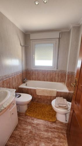 a bathroom with a tub and a toilet and a sink at La Manga del Mar Menor Los Miradores block 1 5th floor G in Murcia