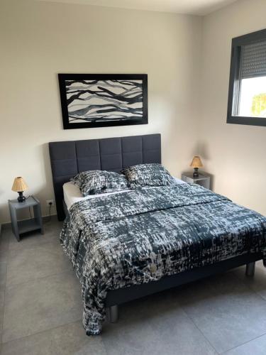 een slaapkamer met een bed met een zwart-wit dekbed bij VILLA M&M in La Seyne-sur-Mer