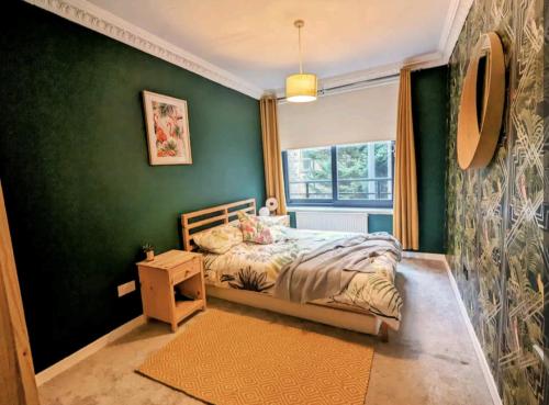 - une chambre avec un lit et un mur vert dans l'établissement One The Mews, à Glasgow