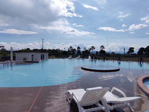 una piscina con sillas en el medio. en Colibrí Cafeterito, en Montenegro