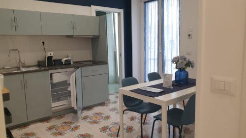 uma cozinha com uma mesa e cadeiras, uma mesa e um balcão em Dafne Home em Pompeia