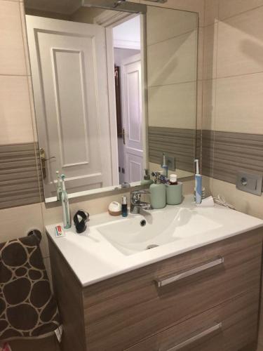 a bathroom with a sink and a large mirror at Bouganvilla in Adeje