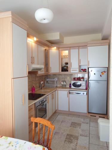 a kitchen with white cabinets and a white refrigerator at Apartment 4 Kullat in Prizren