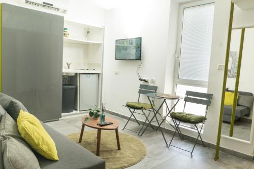 a living room with a couch and a table and chairs at Lily Studio Apart *Top location* in Jerusalem