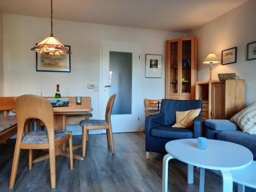 een woonkamer met een tafel en een blauwe bank bij "Ferienhaus Moll" in Grömitz