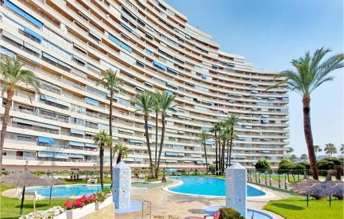 a large apartment building with a swimming pool and palm trees at 1 Bedroom Nice Apartment In Cullera in Cullera