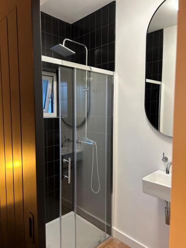 a glass shower in a bathroom with a sink at Brannel Cottage in St Austell