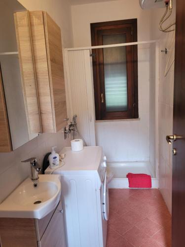 W białej łazience znajduje się umywalka i lustro. w obiekcie Casa Paola w mieście Favignana