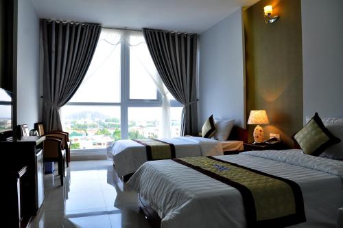 a hotel room with two beds and a window at Cam Thanh Hotel in Quang Ngai