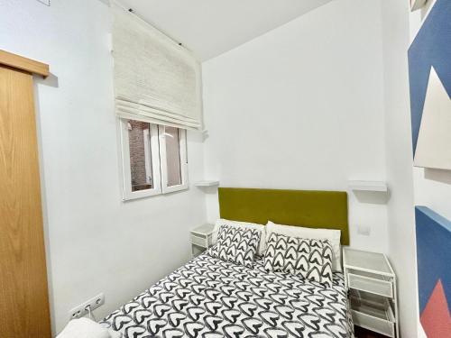 ein kleines Schlafzimmer mit einem Bett und einem Fenster in der Unterkunft Atocha Ferrocarril 5 in Madrid