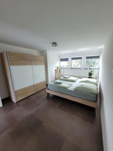a bedroom with a large bed and two windows at Ferienwohnung Bodensee Nähe in Rielasingen-Worblingen