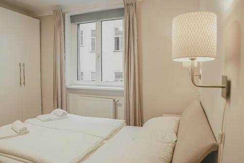 ウィーンにあるHeyMi Apartments Schwedenplatzのベッド2台と窓が備わるホテルルームです。