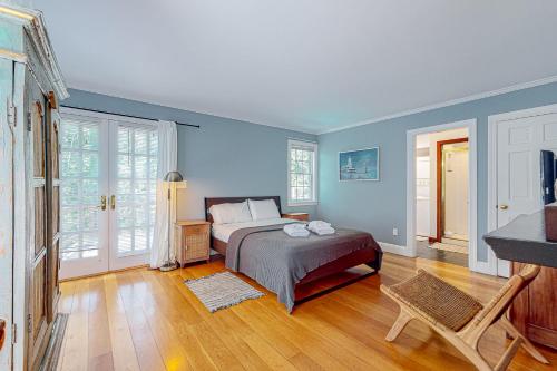 Schlafzimmer mit einem Bett mit blauen Wänden und Holzböden in der Unterkunft Fernbank Hideaway in West Tisbury