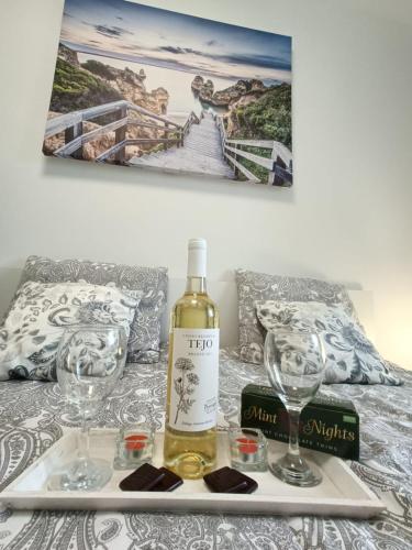 a bottle of wine and two glasses on a bed at Luksusowy Apartament Mario Mare Kołobrzeg in Kołobrzeg
