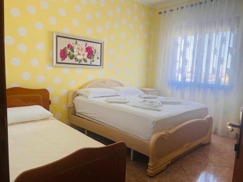 sypialnia z 2 łóżkami i oknem w obiekcie Fori Vodo w mieście Divjaka