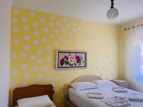 a bedroom with two beds and a polka dot wall at Fori Vodo in Divjakë