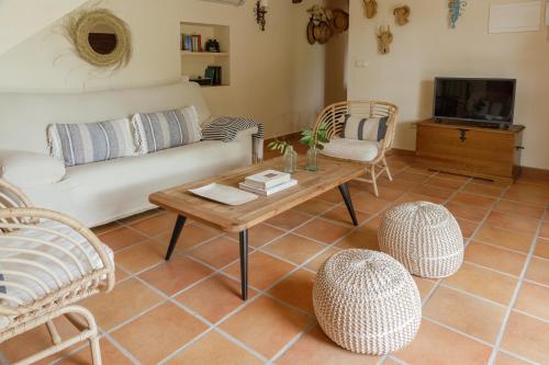 ein Wohnzimmer mit einem Sofa, einem Tisch und Stühlen in der Unterkunft Casa Rural en Candeleda con piscina y un maravilloso jardín in Candeleda