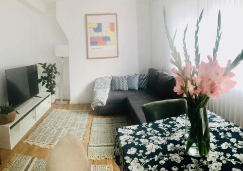 a living room with a couch and a vase of flowers at City location- 2 bedroom apartment in London