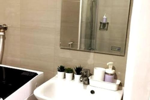 a white bathroom with a sink and a mirror at Andi's blessed home staycation in Manila
