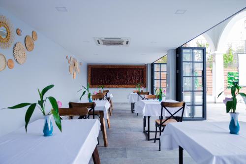 a dining room with white tables and chairs at Solar Hotel in Siem Reap