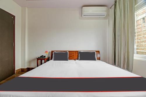a bedroom with a large white bed with a window at Collection O The Grand Megha Resort in Bhutiāgāon