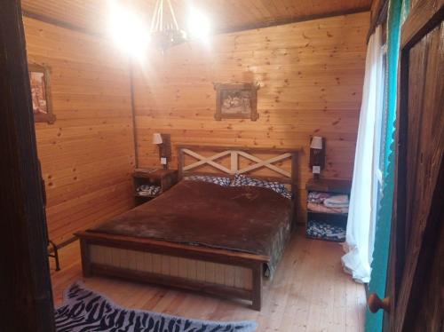 1 dormitorio con 1 cama en una cabaña de madera en Quba A frame en Amsar