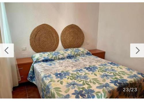 een slaapkamer met een bed met een bloemenbed bij Sahara Playa Barrosa in Chiclana de la Frontera