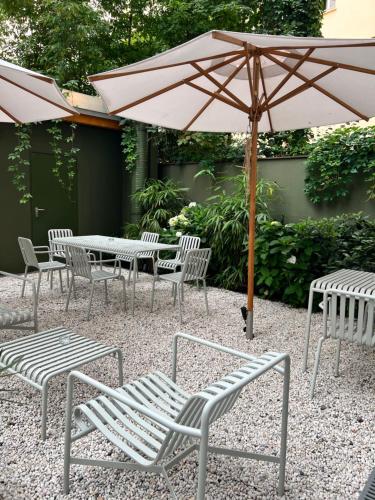 a table and chairs with an umbrella in a courtyard at ADELANTE Boutique Hotel in Berlin