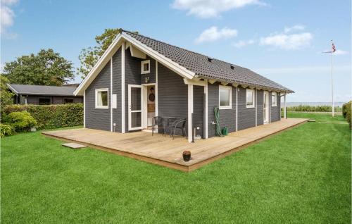 a small house with a wooden deck in a yard at 2 Bedroom Beach Front Home In Sjølund in Sjølund