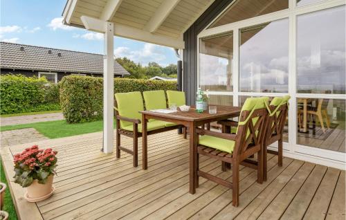 a wooden table and chairs on a wooden deck at 2 Bedroom Beach Front Home In Sjølund in Sjølund