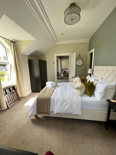 Beinn Mhor Lodge في إينفيرنيس: غرفة نوم بسرير كبير عليها شراشف ووسائد بيضاء