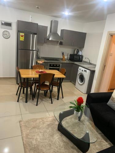 cocina y sala de estar con mesa y sofá en City Views Apartment en Bawaleshi